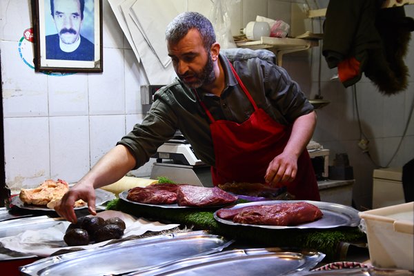 Slager rangschikt vlees in Fez, Marokko