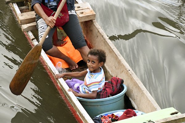 Bootje met vrolijk kind in Sorong, Papoea