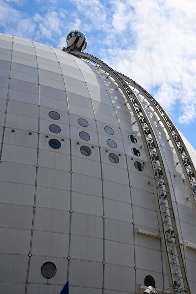 Bolvormige cabine gaat omhoog langs bolvormig gebouw (Skyview, Stockholm)