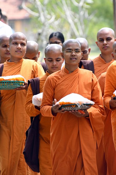 Vrouwelijke monniken met offers bij de Thuparama Dagoba in Anuradhapura (Sri Lanka)
